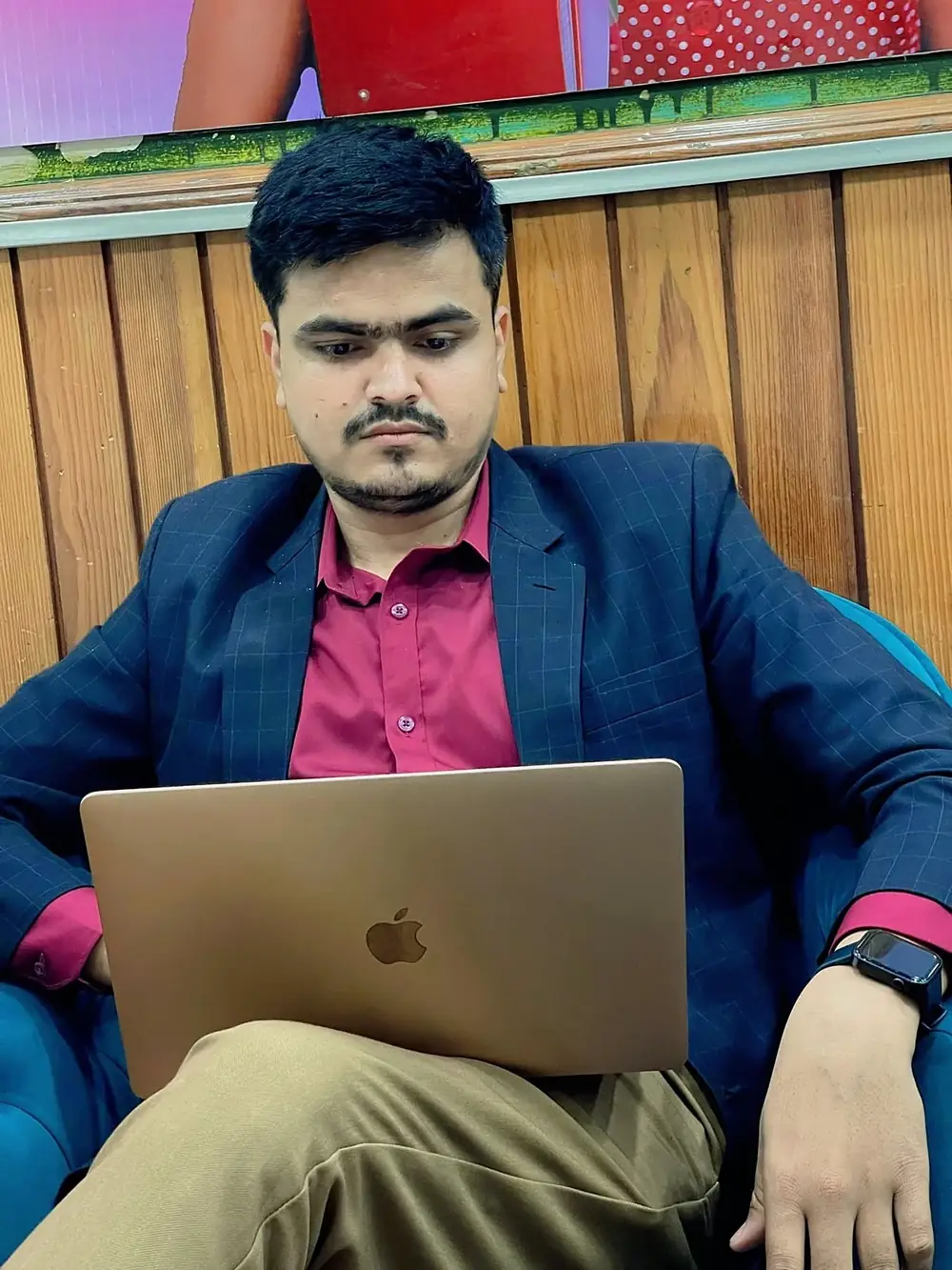 Hemraj Adhikari working on a laptop in a navy blazer