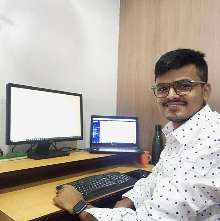 Hemraj smiling at his desk