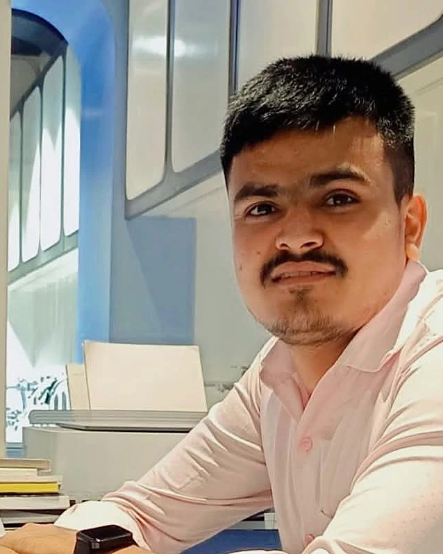 Hemraj at his office desk next to a monitor