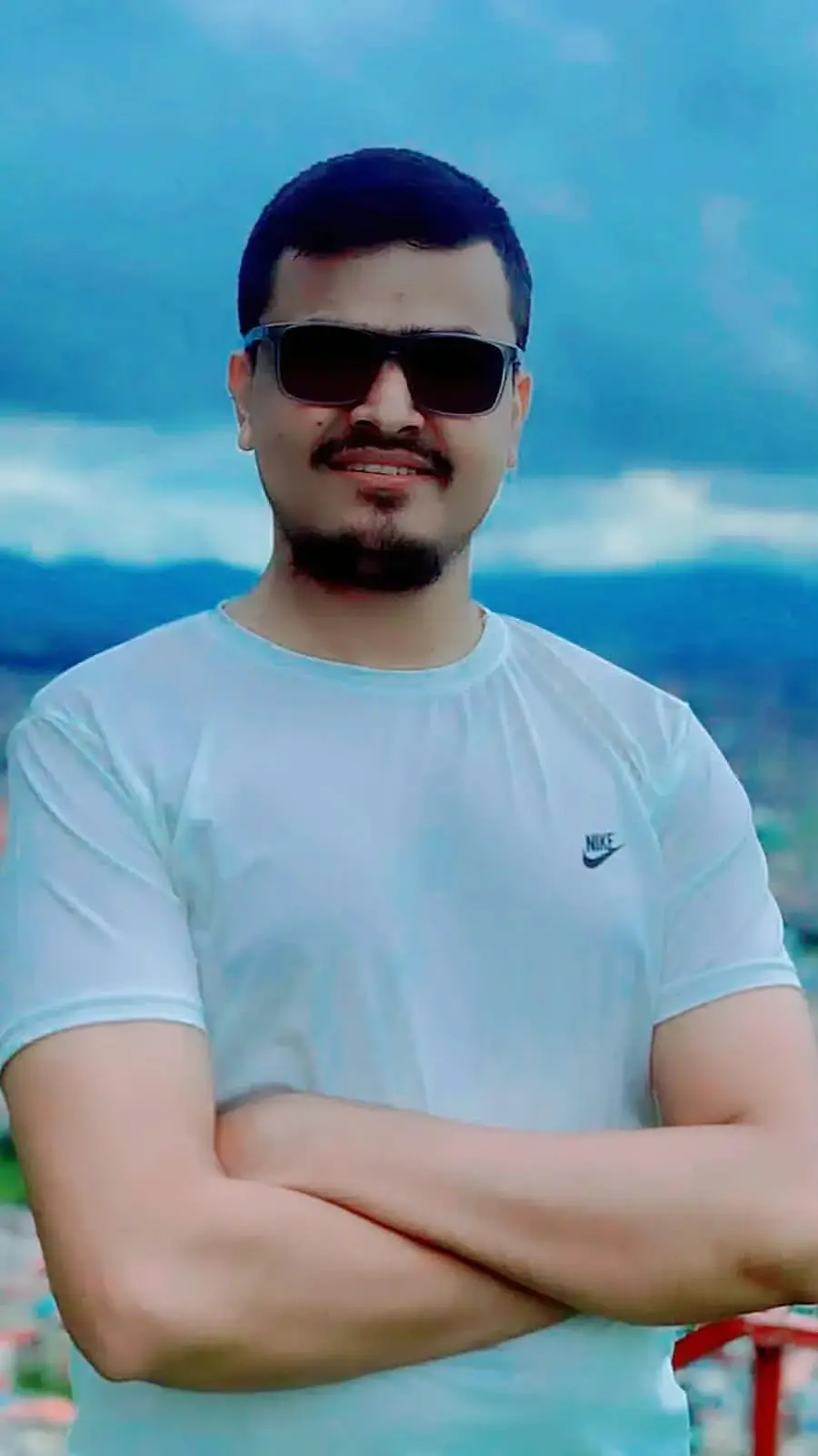Hemraj in sunglasses on a hill above the city