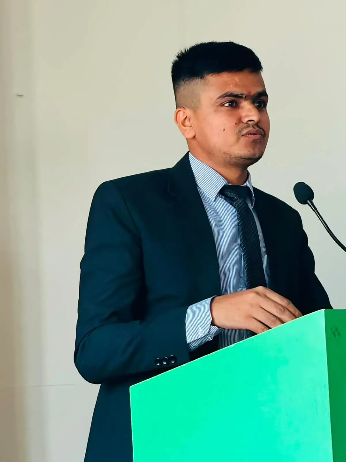 Hemraj speaking at a podium